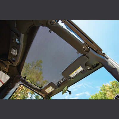 Bestop retractable sunshade in black mesh installed on an open Jeep roof with blue sky in background