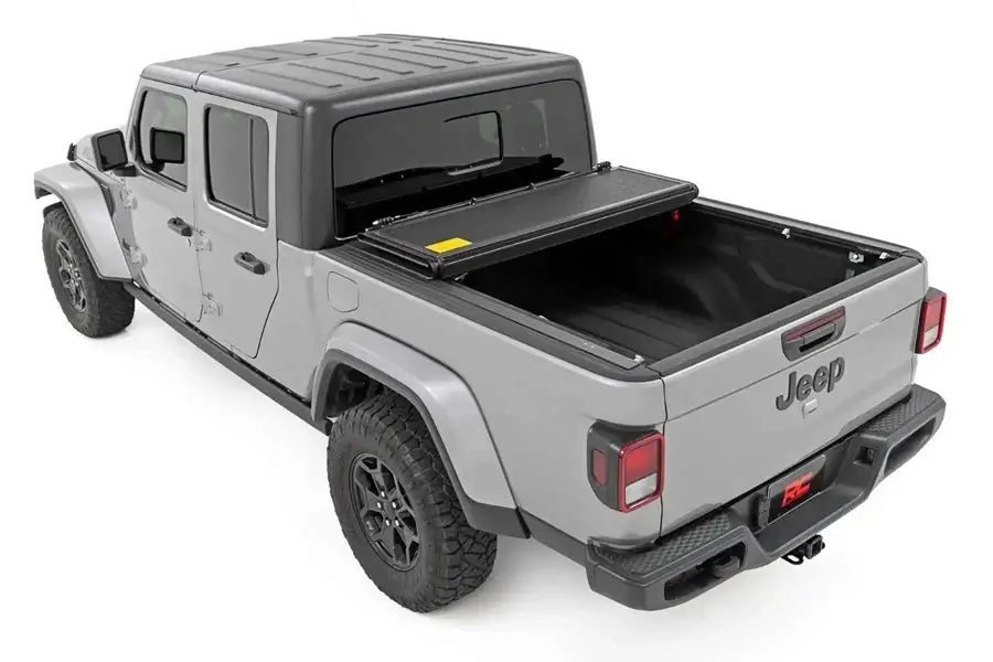 ROUGH COUNTRY Low Profile Tri-Fold Bed Cover on 5ft Jeep Truck Bed - sleek, secure protection for your cargo.